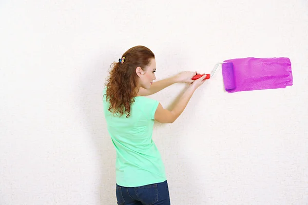 Jeune femme peint mur dans un nouvel appartement — Photo