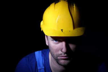 genç bir işçi koyu arka plan üzerinde portresi