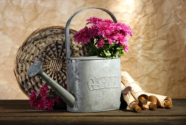 Bouquet of pink chrysanthemum in watering can on wooden table — Stock Photo, Image