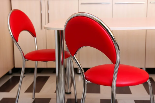 Modern red chairs near table in kitchen — Stock Photo, Image