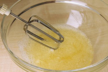 Yemek, yumurta bir kapta elektrikli çırpma teli ile kırbaçlanan, yakın çekim