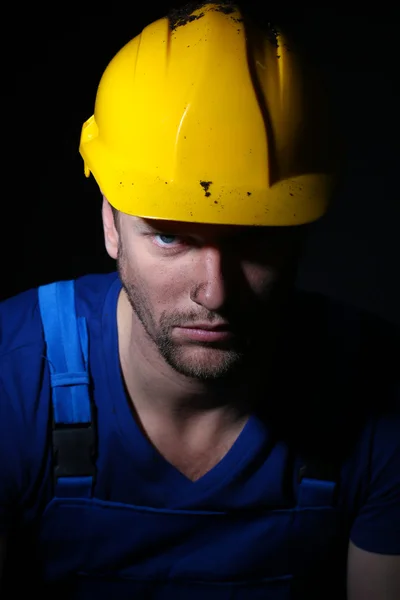 Portrait of young worker on dark background — Stock Photo, Image