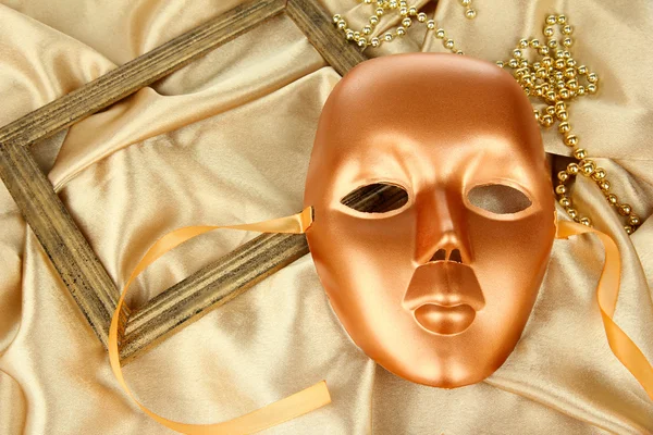Maske auf goldenem Stoff Hintergrund — Stockfoto