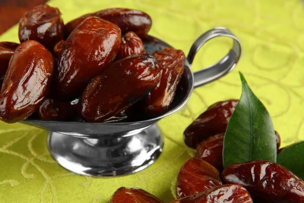 Dried dates in metal dish on fabric background — Stock Photo, Image