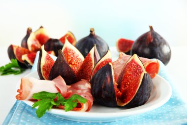 Tasty figs with ham on plate