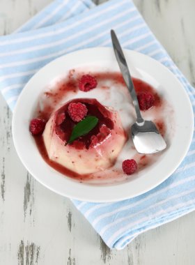 Panna cotta ahşap zemin üzerinde frambuaz sos ile