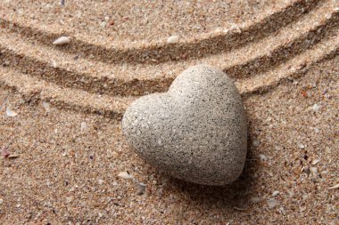 Gri zen stone kum arka plan üzerinde kalp şeklinde