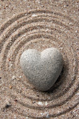 Gri zen stone kum arka plan üzerinde kalp şeklinde