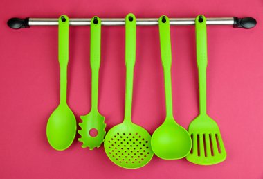 Plastik mutfak eşyaları üzerinde kırmızı zemin üzerine gümüş kanca