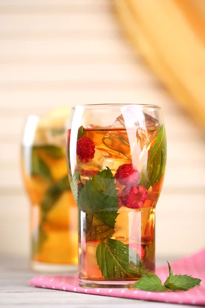 Té helado con frambuesas, limón y menta en una mesa de madera — Foto de Stock