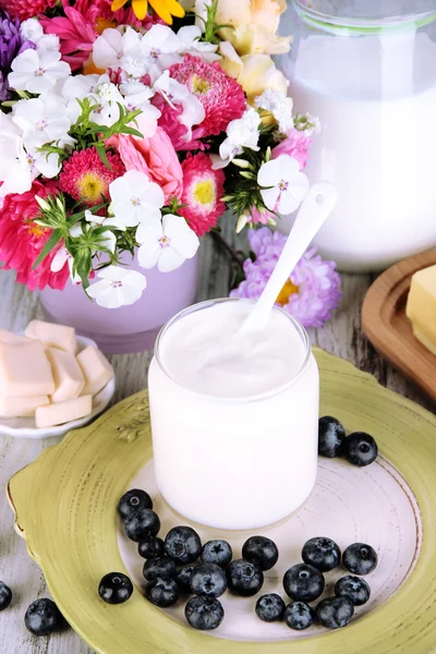 Свежие молочные продукты с черникой на деревянном столе крупным планом — стоковое фото
