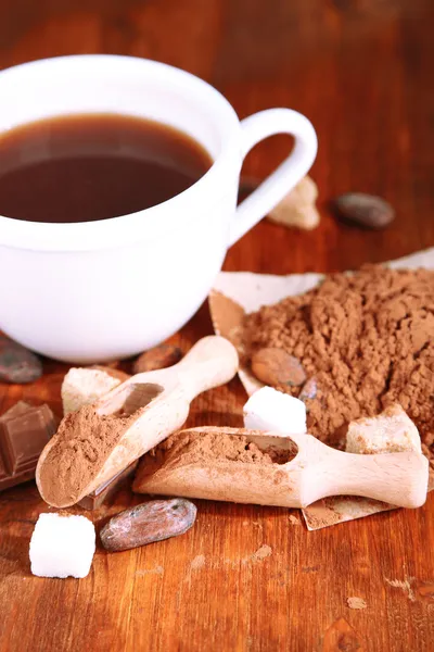 Cacau em xícara e pó de coca na mesa de madeira — Fotografia de Stock