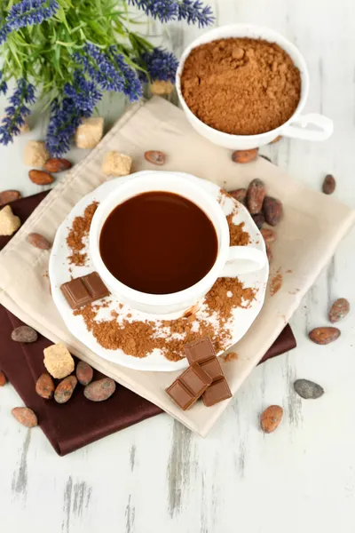 Kakaopulver in Tasse auf Serviette auf Holztisch — Stockfoto