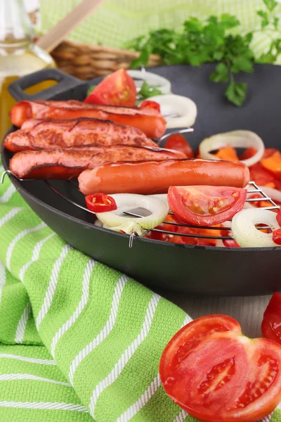 Delicious sausages with vegetables in wok on wooden table close-up — Stock Photo, Image