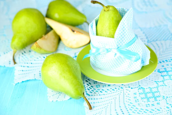 Birne in Serviette auf Teller auf Holztisch in Großaufnahme — Stockfoto