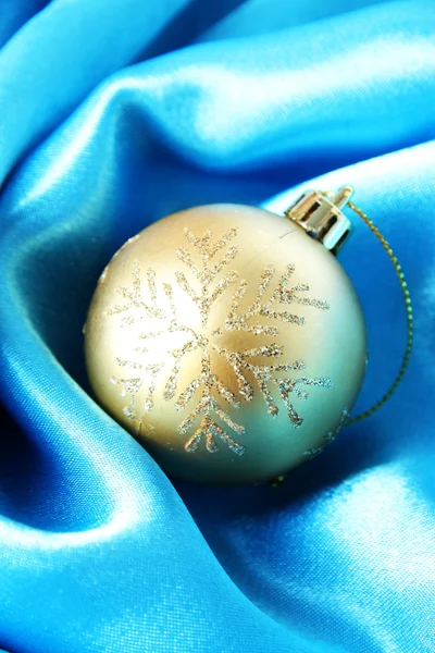 Beautiful Christmas ball on blue satin cloth — Stock Photo, Image