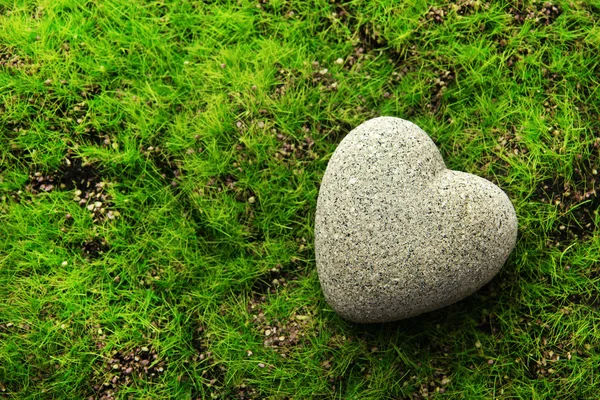 Piedra gris en forma de corazón, sobre fondo de hierba —  Fotos de Stock