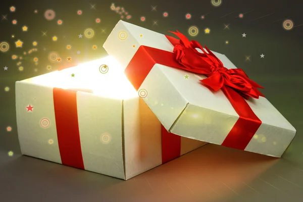 Caja de regalo con luz brillante sobre fondo gris —  Fotos de Stock