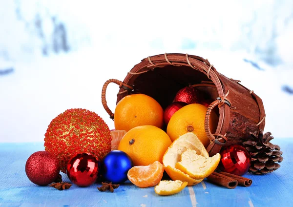 Boże Narodzenie mandarynki i Boże Narodzenie zabawki na drewnianym stole na tle śniegu — Zdjęcie stockowe