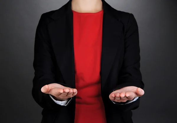 Female hands showing something on grey background — Stock Photo, Image