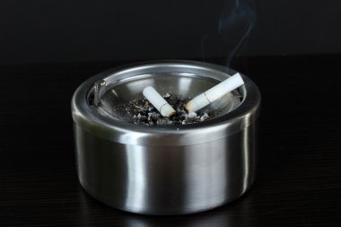 metal kül tablası ile sigara, siyah üzerine izole
