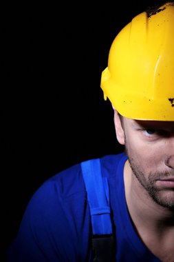 genç bir işçi koyu arka plan üzerinde portresi