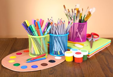 Composition of various creative tools on table on beige background clipart