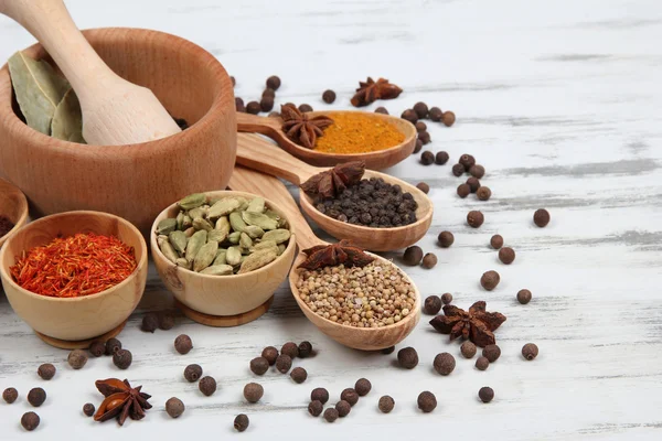 Various spices and herbs on wooden background — Stock Photo, Image