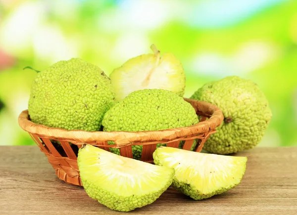 Osage Frutos de naranja (Maclura pomifera) en cesta, sobre mesa de madera, sobre fondo natural —  Fotos de Stock