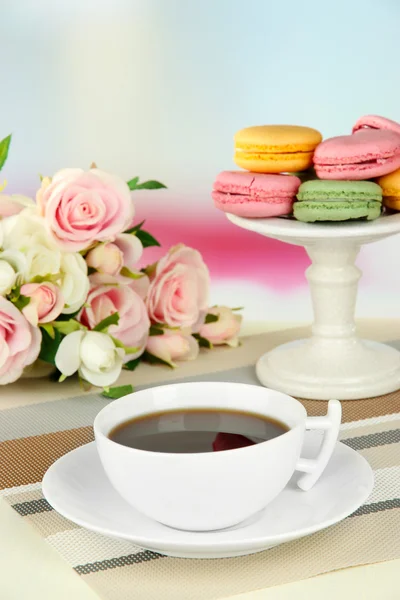 Kaffee und Makronen auf dem Tisch vor hellem Hintergrund — Stockfoto