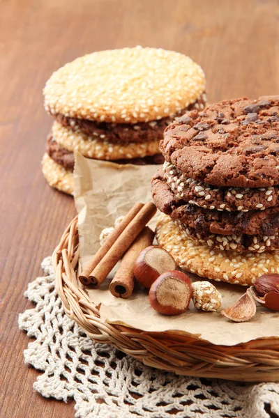 Homemade cookies with sesame seeds, chocolate, on napkin, on wooden background — Stock Photo, Image