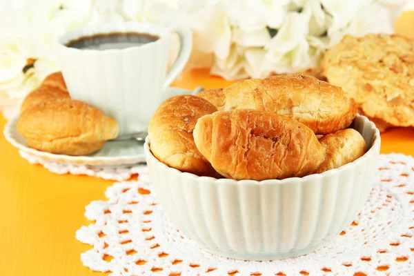 Croissants saborosos e xícara de café na mesa close-up — Fotografia de Stock
