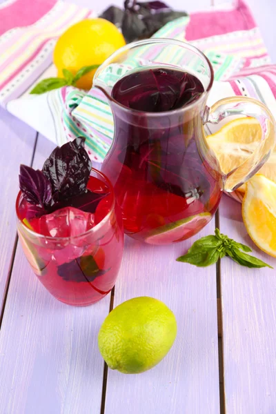 Red basil lemonade in jug and glass, on wooden background — Stock Photo, Image