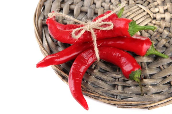 Pimientos rojos picantes en estera de mimbre, aislados en blanco — Foto de Stock