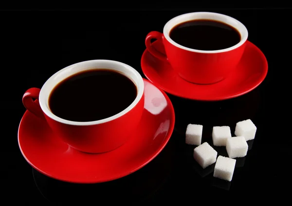 Red cups of strong coffee and sugar isolated on black — Stock Photo, Image