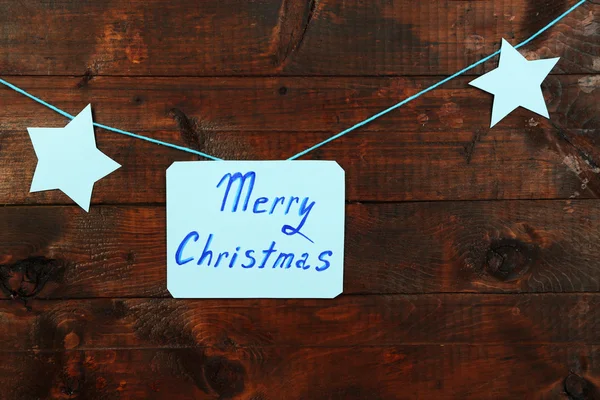 看板と茶色の木製のテーブルの背景はクローズ アップにメリー クリスマスを言葉します。 — ストック写真
