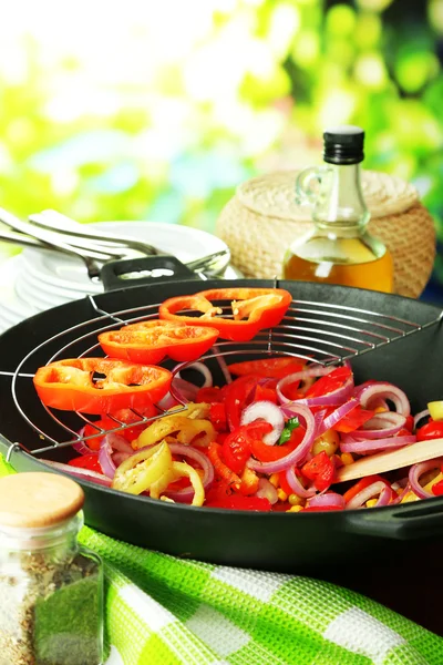 Vegetables in wok on wooden table on natural background — Stock Photo, Image