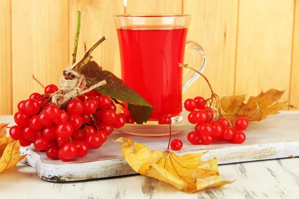 Rode bessen van planten van viburnum en kopje thee op tafel op houten achtergrond — Stockfoto