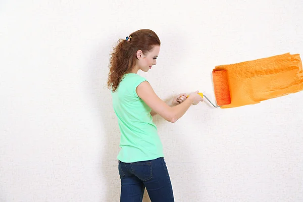 Jonge vrouw verven muur in nieuwe flat — Stockfoto