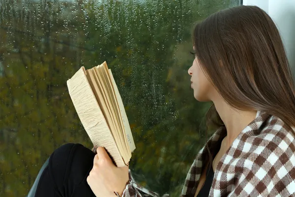 Lonely sad woman looking through window — Stock Photo, Image