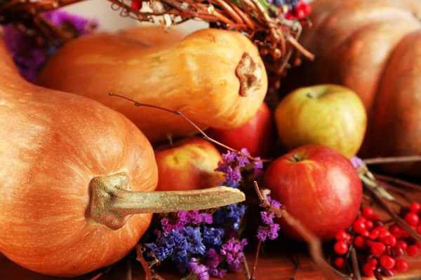 Composition automnale des pommes, citrouilles, fleurs et branches sèches sur table en bois close-up — Photo