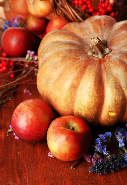 Herbstliche Komposition aus Äpfeln, Kürbissen, Blumen und trockenen Zweigen auf Holztisch in Großaufnahme — Stockfoto