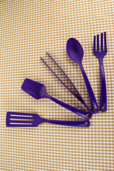 Plastic kitchen utensils on fabric background — Stock Photo, Image