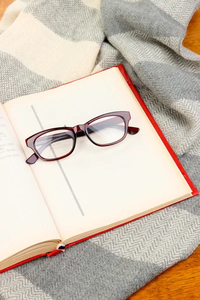 Composition with old book, eye glasses and plaid on wooden background — Stock Photo, Image