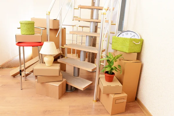 Montón de cajas de cartón cerca de escaleras: concepto de casa móvil —  Fotos de Stock