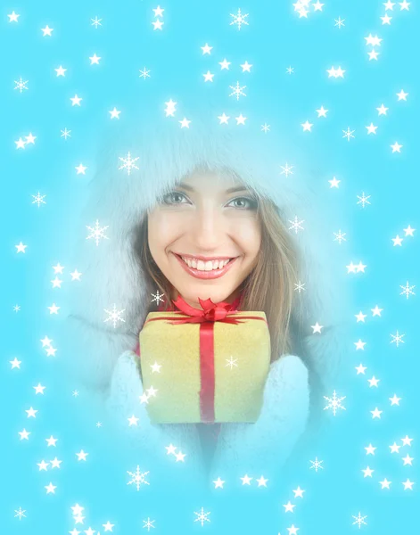 Noel hediyesi olarak mavi arka plan ile şapkalı güzel gülümseyen kız — Stok fotoğraf