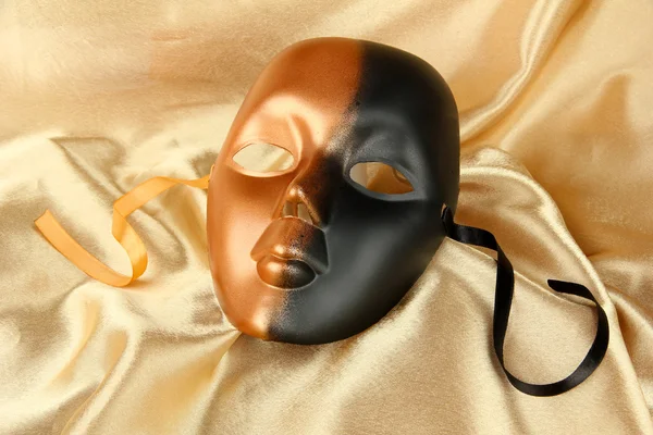 Mask on gold fabric background — Stock Photo, Image