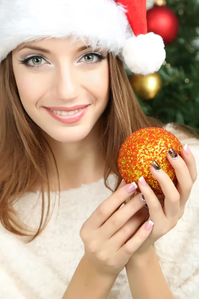 Krásná usměvavá dívka u vánočního stromu v místnosti — Stock fotografie