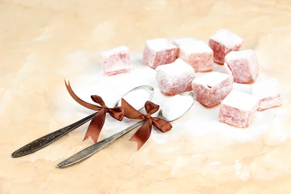 Tasty oriental sweets (Turkish delight) with powdered sugar, on brown background — Stock Photo, Image