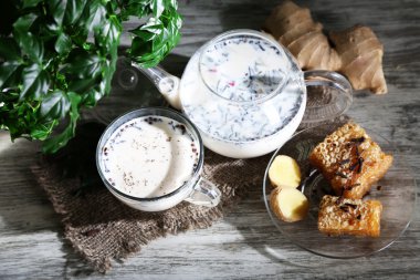 çaydanlık ve çay süt ve baharatlar üstünde çul ahşap tablo